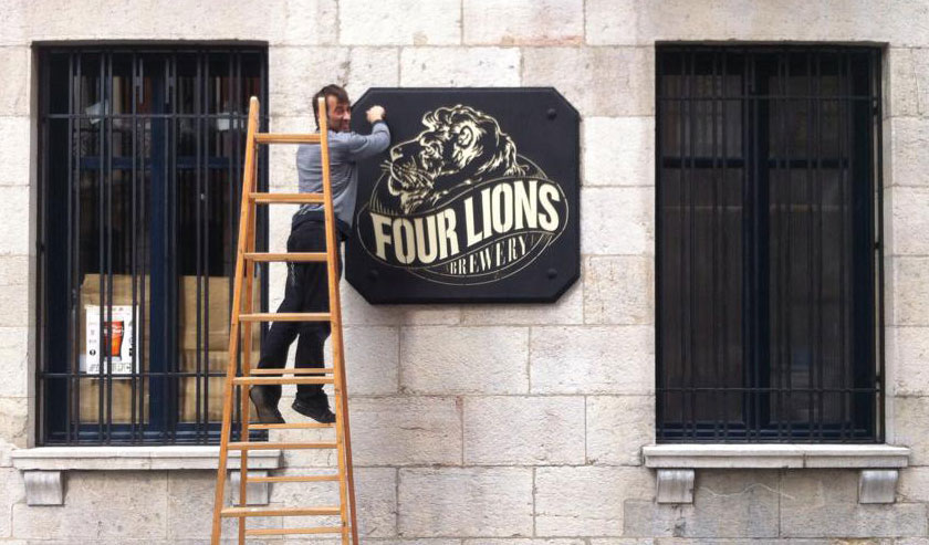 Owner Miguel Llorente Sr. proudly installs his brewery's sign.